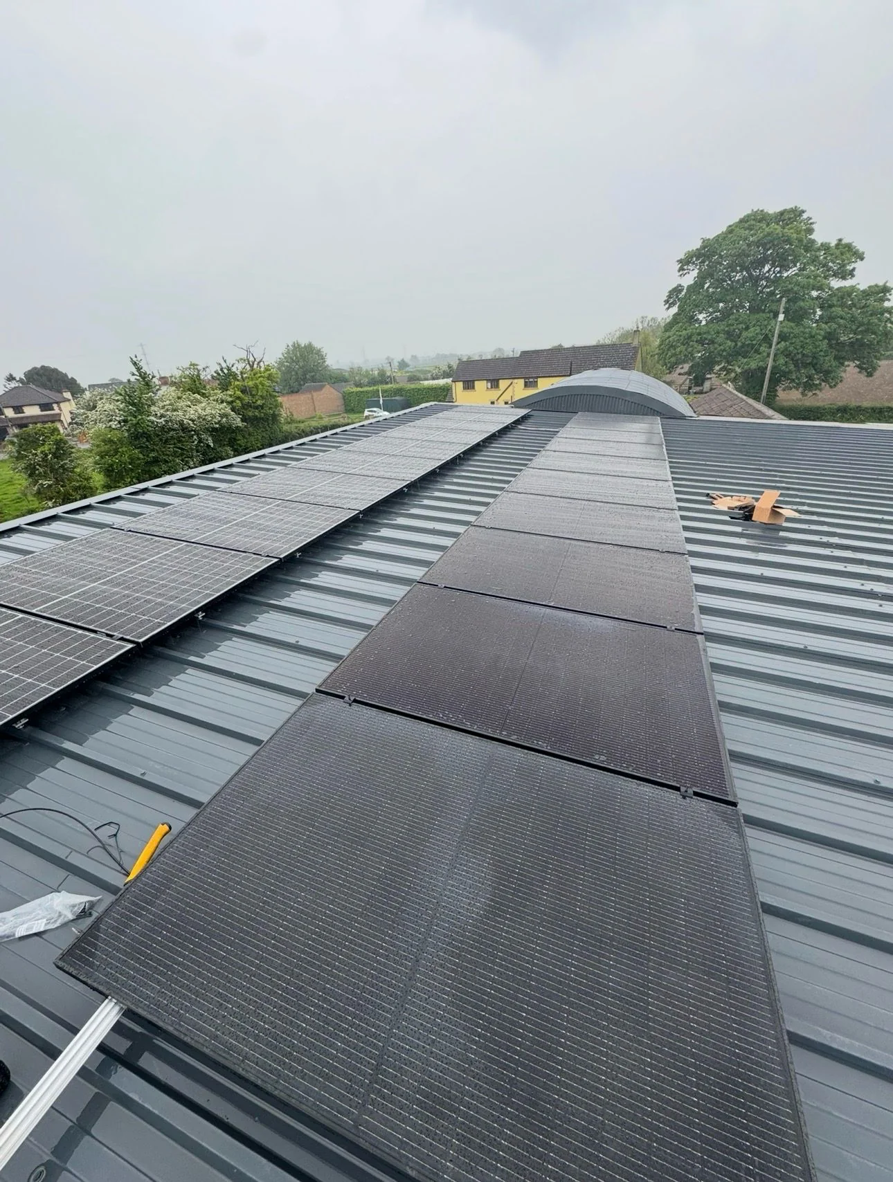 Solar panels across a metal commercial roof, second building