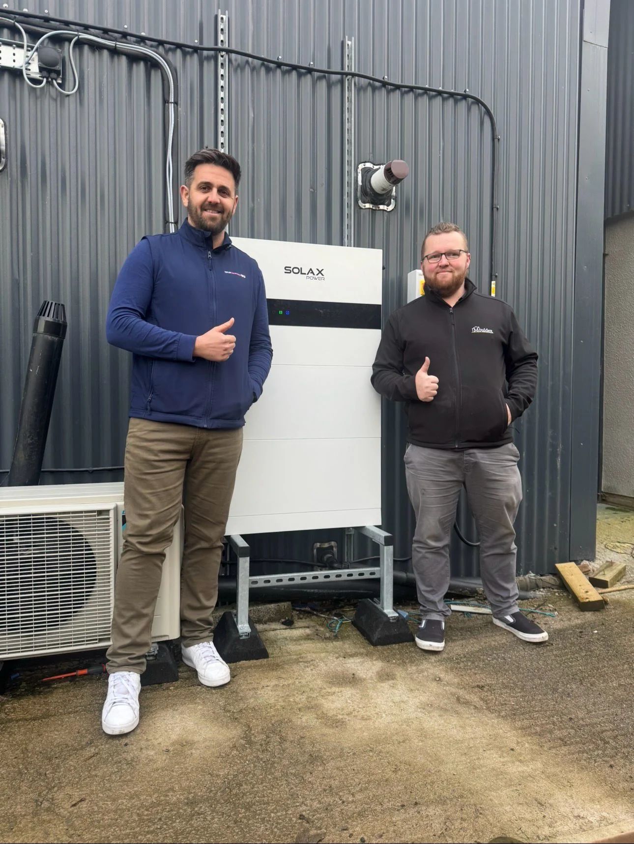 Chris from Totum Renewables with the Mouldex customer beside the battery install