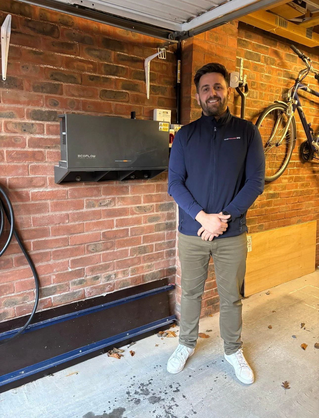 Chris beside the EcoFlow hybrid inverter installed in the garage