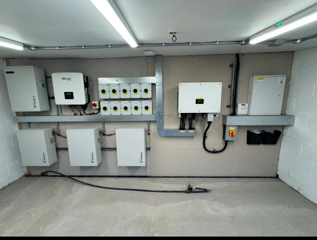 Commercial inverter and battery installation on a plant-room wall