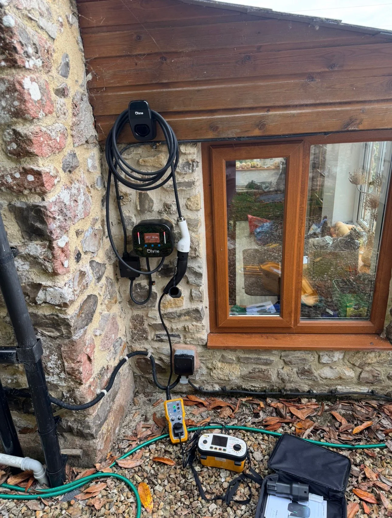 Ohme EV charger fitted to a stone cottage wall