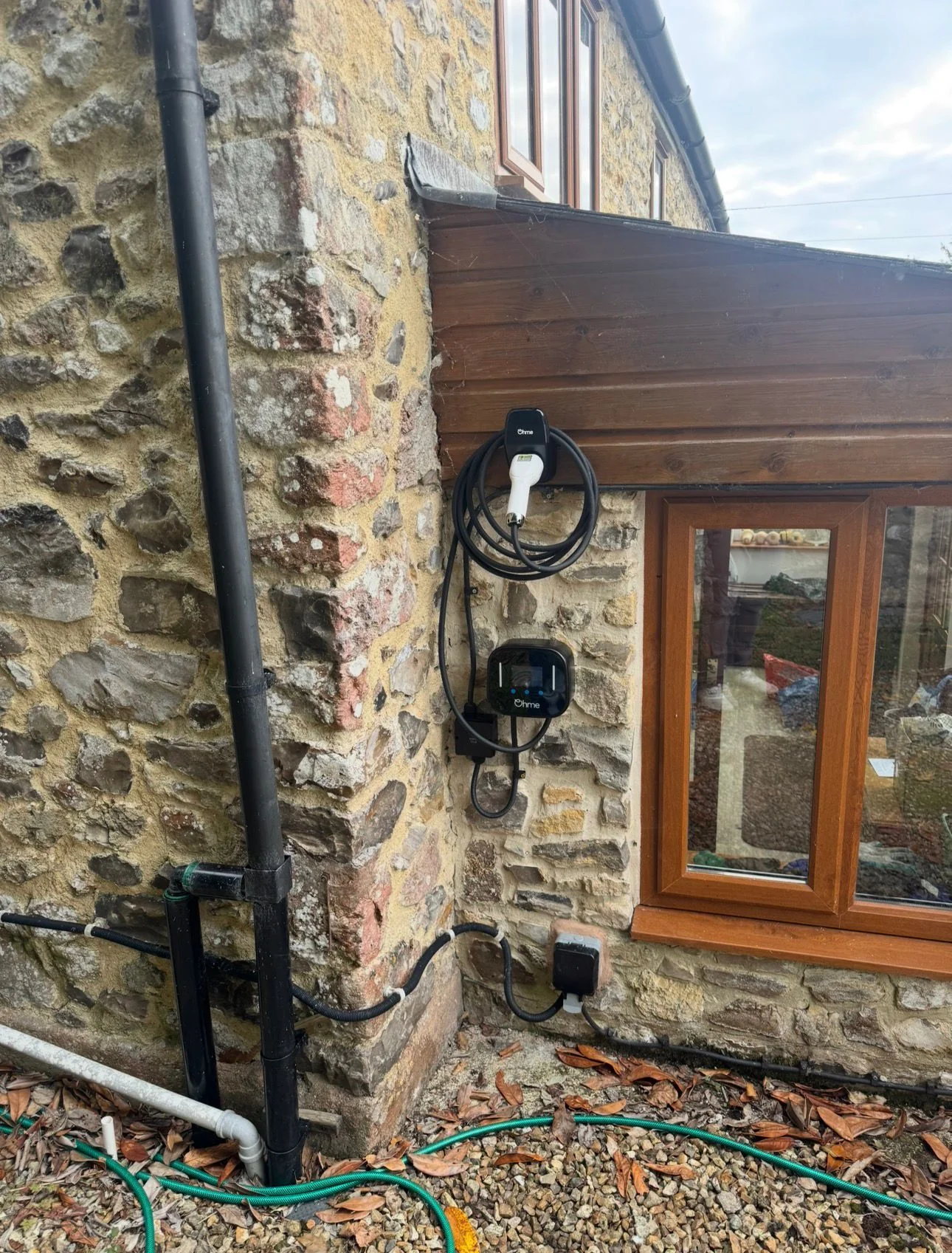 Close view of an Ohme EV charger and isolator on stone