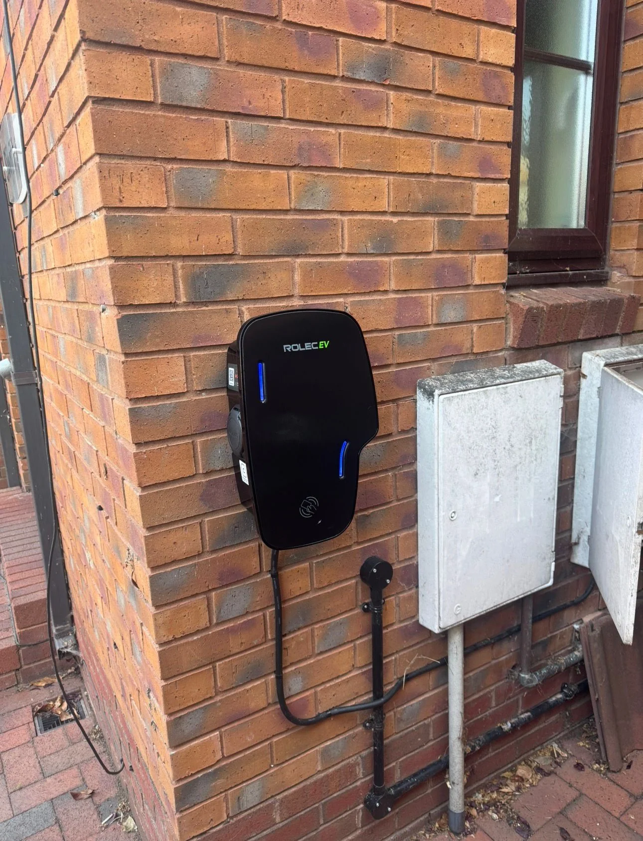Ohme EV charger with neat cable management on stone